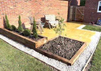 Landscaping in Castle Donington with paved patio, oak sleeper raised beds, gravel edging and planting