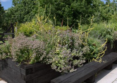 Dark sleeper raised planters with integrated seating and planting, landscaping in Spondon