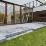 Granite patio with steps down to a freshly turfed lawn at a modern home in Belper
