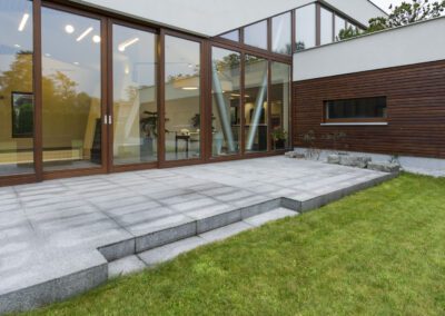 Granite patio with steps down to a freshly turfed lawn at a modern home in Belper