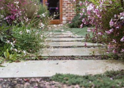 Stepping-stone paving slab path with gravel joints and cottage-style planting in a Hilton garden