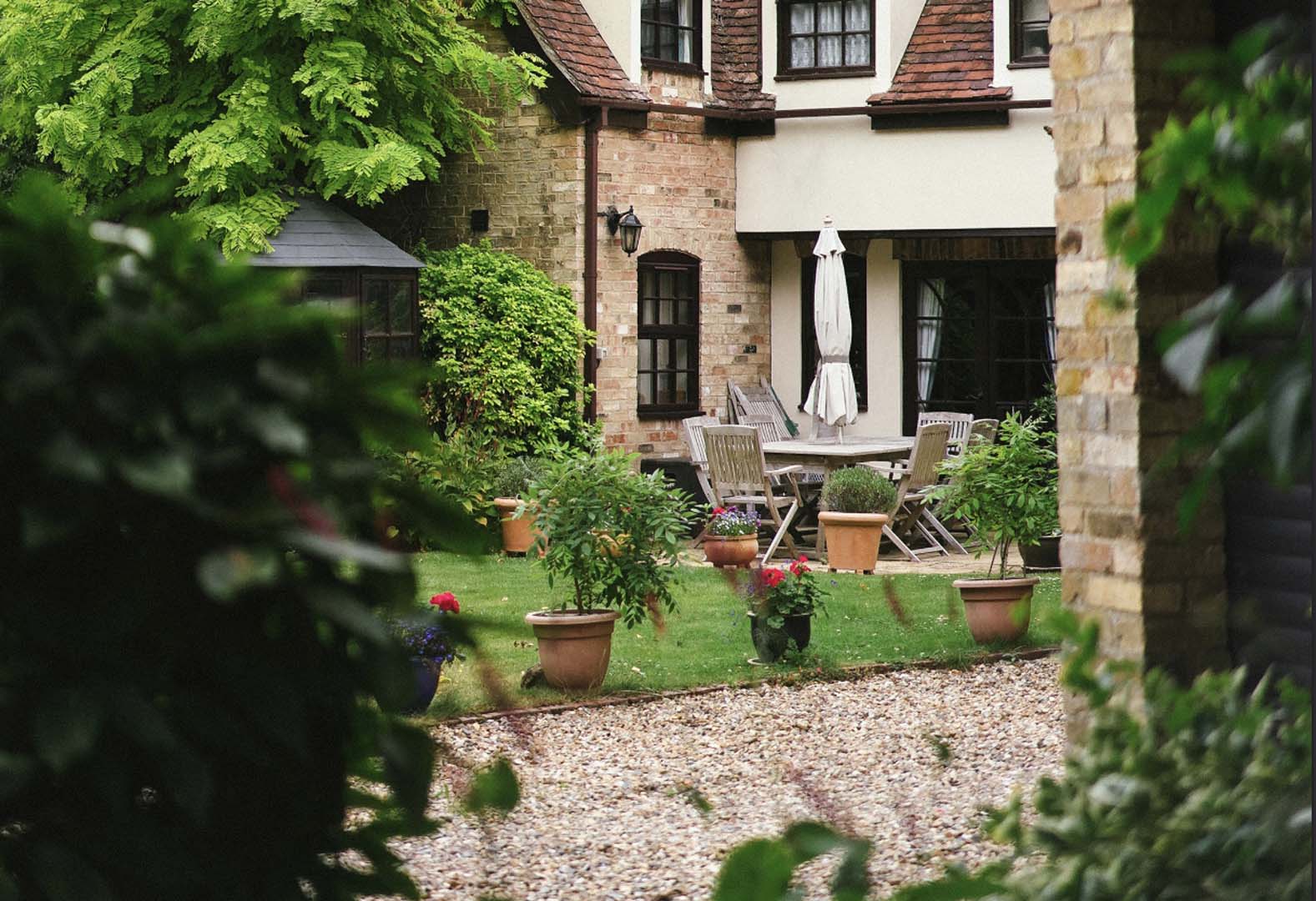 Garden maintenance in Allestree with neatly cut lawn, gravel area and well-kept potted plants in a courtyard garden