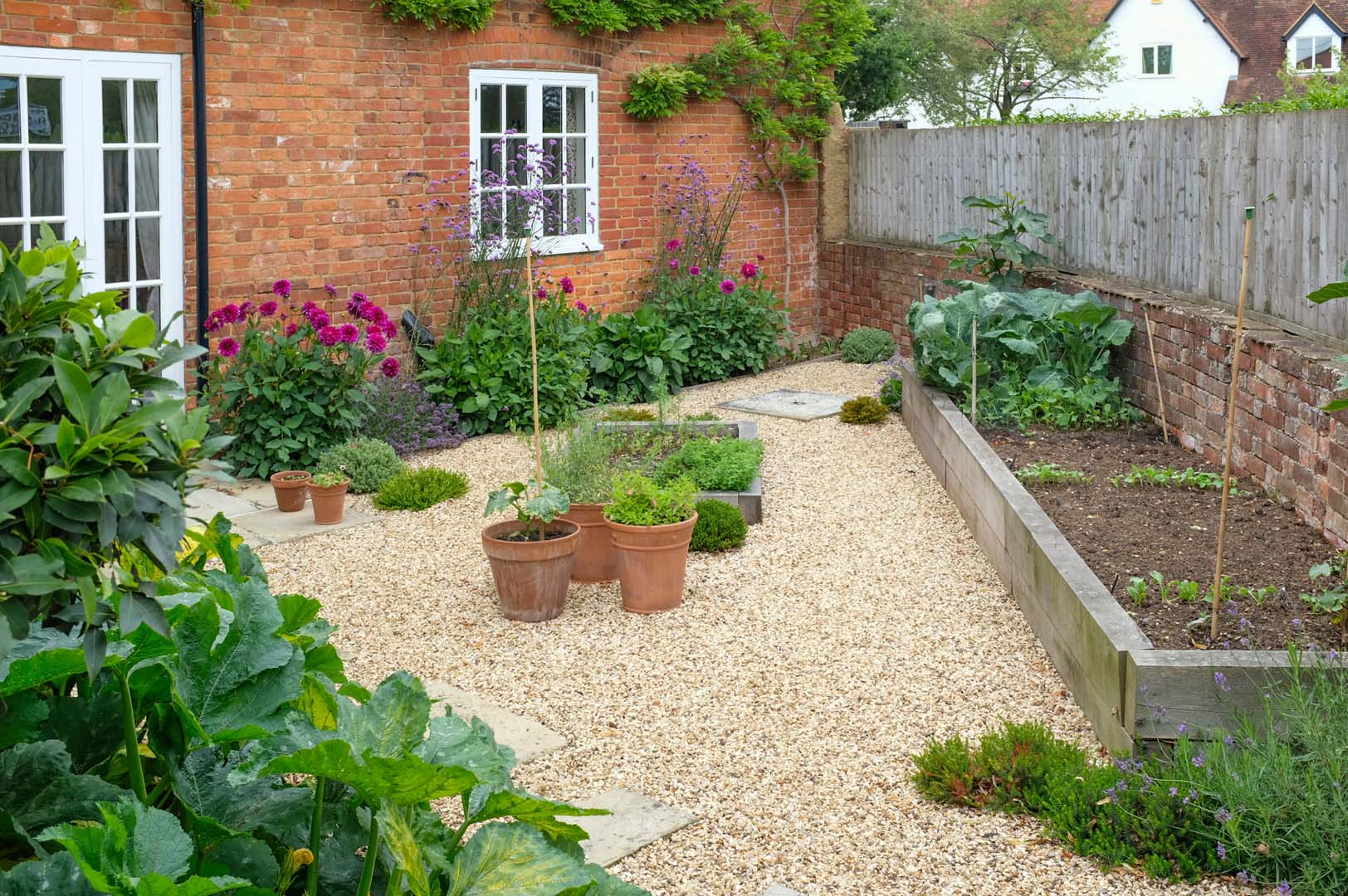 Garden maintenance in Ockbrook with a tidy gravel courtyard, maintained borders and a well-kept raised bed